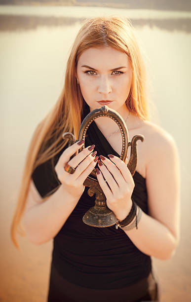 istock gothic girl with long red hair and old mirror 531759797