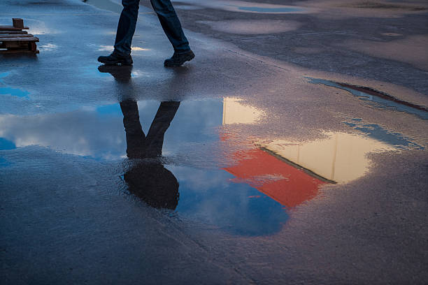 istock Low Section Of Worker Walking On Wet Street 531771828