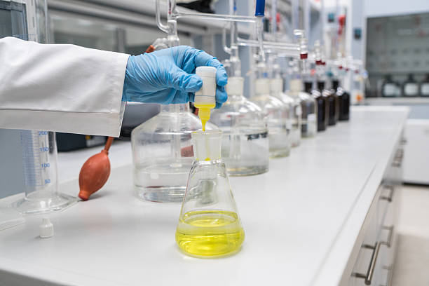 Labrotory Glassware Close up of human hand organizing beakers with solutions in lab, horizontal composition, selective focus beaker pour stock pictures, royalty-free photos & images