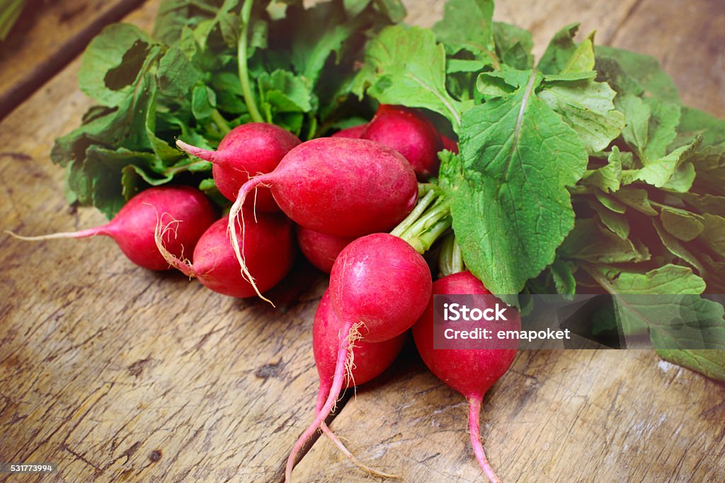 Fresh radishes on old wooden table Radish Stock Photo