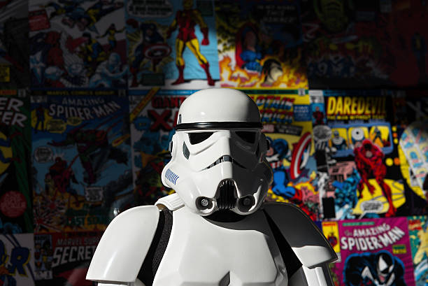 Star Wars white Imperial Stormtrooper action figure Madrid, Spain - November 30, 2014: Head shot of a white Imperial Stormtrooper action figure against a colorful wall, covered with old Marvel Super-heroes comic books (Spiderman, Daredevil, X-Men, Iron Man...). The Imperial Stormtroopers are fictional soldiers from George Lucas' Star Wars universe. They are the main ground-force of the Galactic Empire, impossible to sway from the Imperial cause. They wear imposing white armor, which offers a wide range of survival equipment and temperature controls to allow the soldiers to survive in almost any environment.  action figure stock pictures, royalty-free photos & images