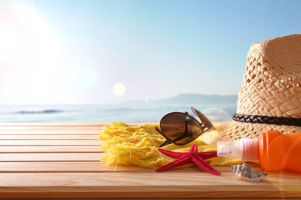 Beach articles on a table wooden slats and sea background