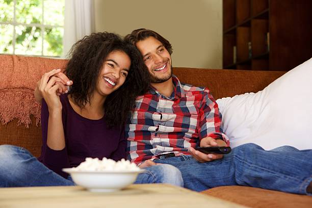 istock Smiling boyfriend and girlfriend relaxing watching tv 531779616