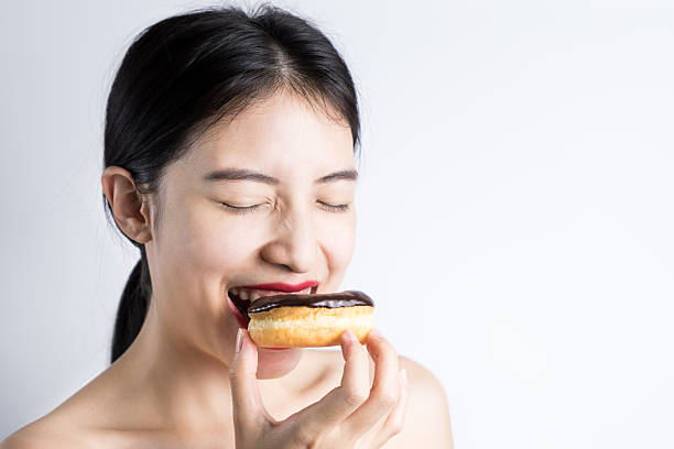 istock Asian Woman eating donut on white background 531779910