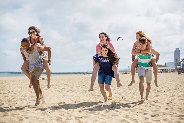 istock Youngsters giving piggyback ride to friends on beach 531782646