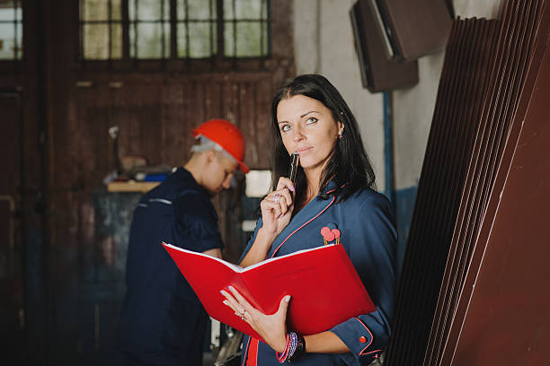 istock female chief stands against a worker at metal cutting machine 531783694