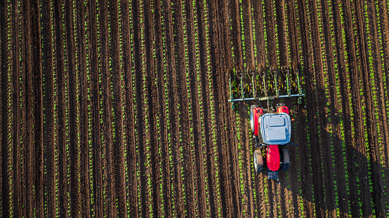 Tractor cultivating field at spring,aerial view