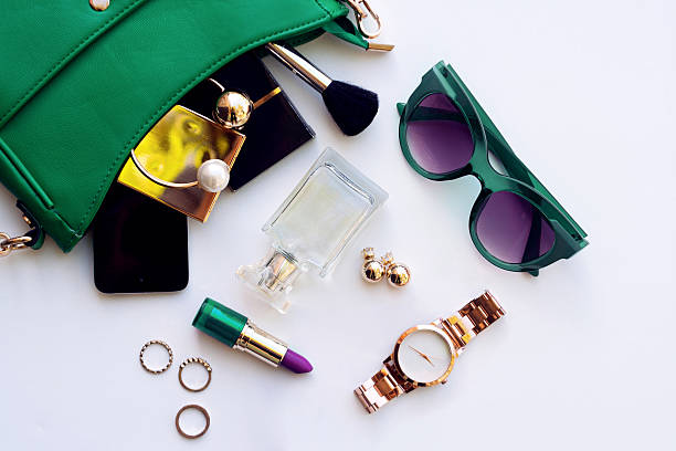 Top view of female fashion accessories Top view of female fashion accessories . Green hanbag with  sunglasses,  gold watch , lipstick , perfume , rings , smartphone personal accessory stock pictures, royalty-free photos & images