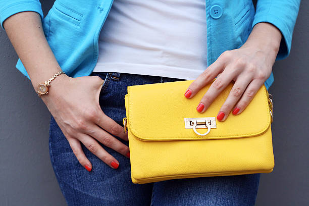 istock woman with yellow handbag clutch gray background 531786496