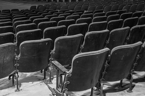 Black and white vintage velvet theater seating in declining movie theater.