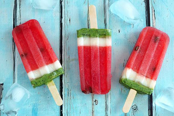 istock Homemade watermelon popsicles with ice against rustic blue wood 531791186