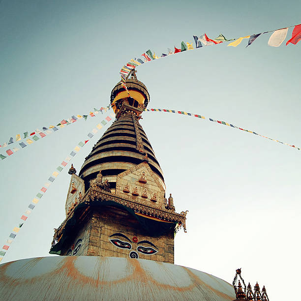 Buddhist shrine Swayambhunath Stupa - vintage filter. Stupa with Buddha wisdom eyes and praying flags - retro effect. Colorful praying flags and stupa, Kathmandu, Nepal.