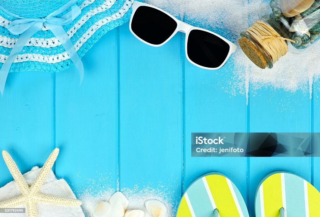 Double border of beach items and seashells on blue wood Summer double border of beach items and sea shells on blue wooden background Sea Stock Photo