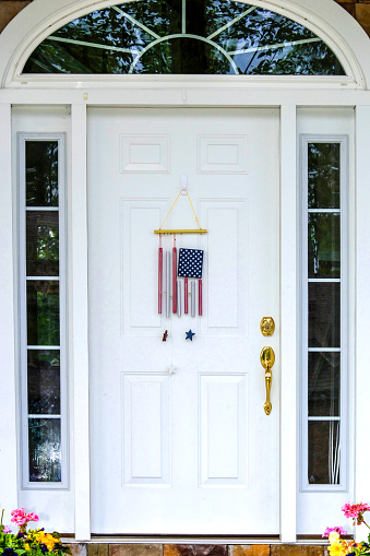 July 4th American flag decoration hanging from a white residential front door in Port Huron Michigan