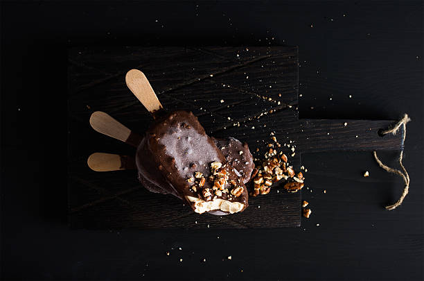 cioccolato con nocciole scheggiato ghiaccioli sulla tavola in legno scuro - yoghurt coated foto e immagini stock