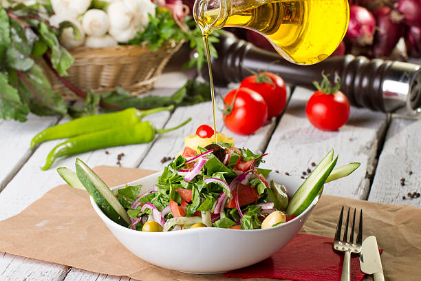 olive oil with bowl of salad stock photo