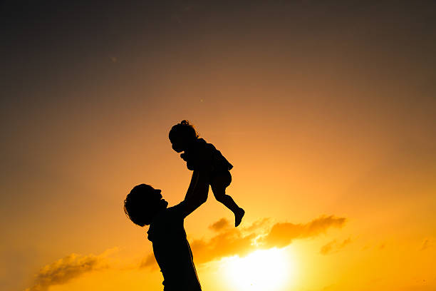 istock Father and little daughter silhouettes at sunset 531799526