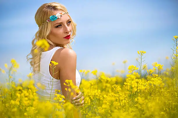 Attractive woman in yellow field, concept dreaming and  freedom