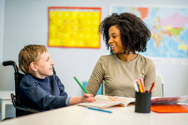 Boy with Developmental Disability A child with special needs due to chromosome 8P inversion duplication syndrome with a volunteer. special education stock pictures, royalty-free photos & images