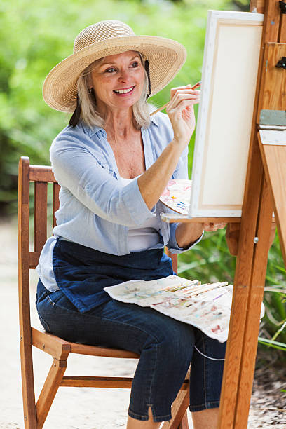 istock Senior woman sitting outdoors, painting 531841357