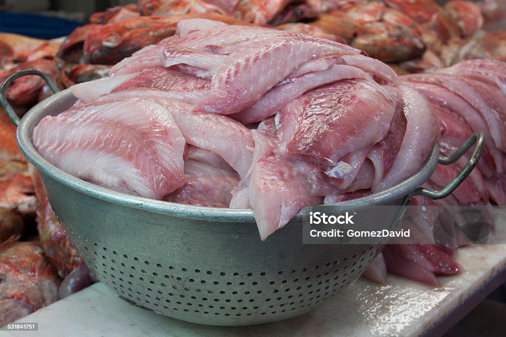 Fresh Snapper In Colander After Being Filleted Colander of fresh filleted red snapper ready for market. 2015 Stock Photo