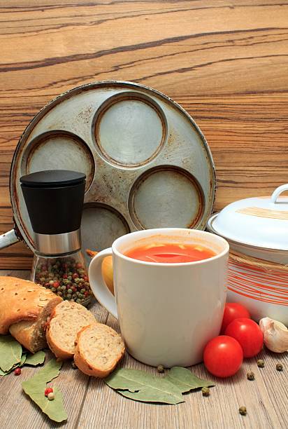 Tomato soup in a cup with bread and vegetable around