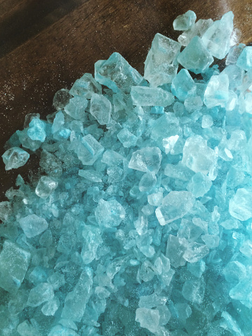 A large amount of crystal meth that has a blue color like the TV show Breaking Bad. The crystals are spilled out across a table. The image is vertical (stock image).