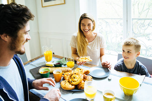 heureuse famille petit déjeuner à la maison - butter bread breakfast table photos et images de collection