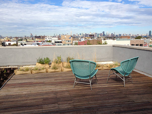 Rooftop in Brooklyn with two green wicker chairs on hardwood floors