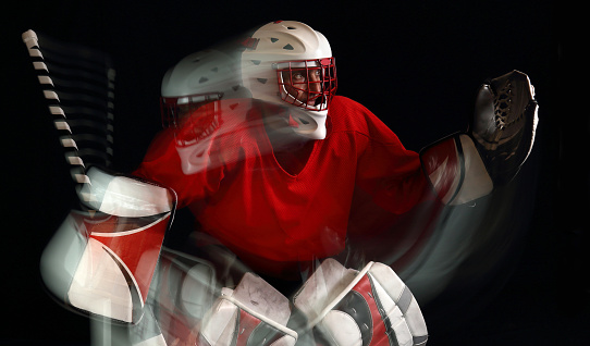 Studio photo of a hockey goaltender using second-curtain flash to capture motion trails and give an 