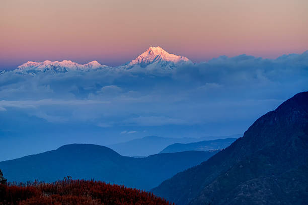 Sunrise on Mount Kanchenjugha, at Dawn, Sikkim Beautiful  first light from sunrise on Mount Kanchenjugha, Himalayan mountain range, Sikkim, India. Blue coloured clouds surrounded the mountains at dawn kangchenjunga stock pictures, royalty-free photos & images