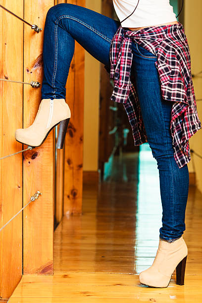 Young people concept - woman legs in denim trousers dancing, girl relaxing at home