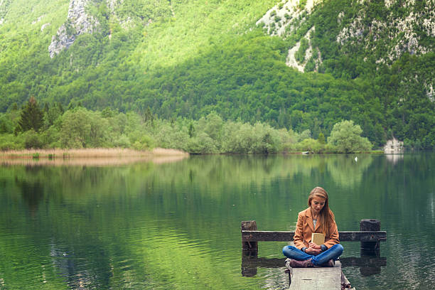 istock girl reading a book in the nature 531859838