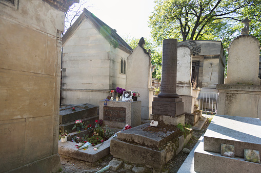 Paris, France - May 1, 2016: Many people come to visit and lay flowers on the grave of Jim Morrison from the Doors, His grave is on the cemetary Pere Lachaise in Paris France