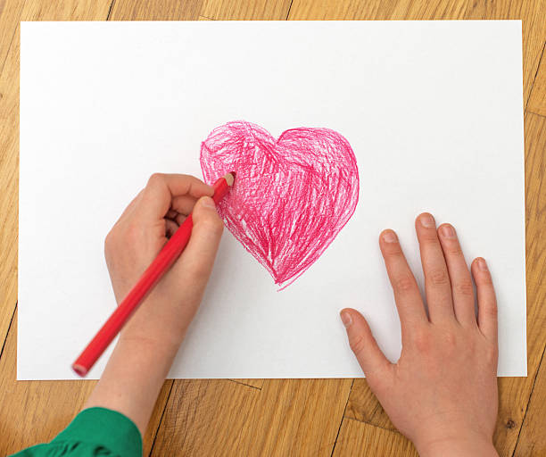 istock Child's hand drawing red heart on paper. 531860494