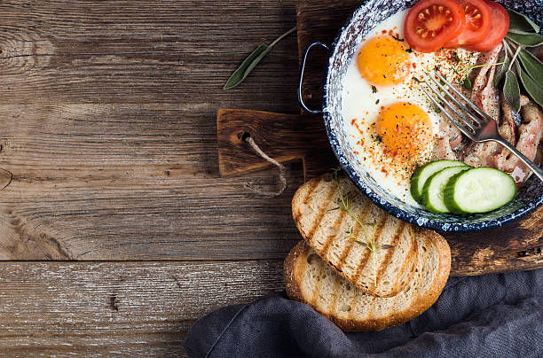 istock Breakfast set. Pan of fried eggs with bacon, fresh tomato 531860584