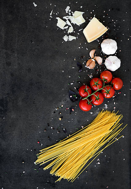 speisen rahmen. pasta zubereitet. cherry-tomaten, spaghetti nudeln, knoblauch und basilikum - italian culture ingredient spaghetti food stock-fotos und bilder