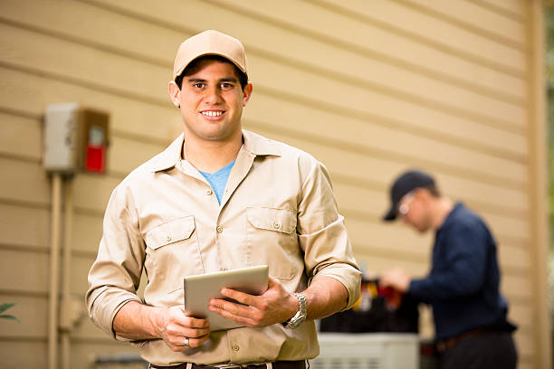 istock Air conditioner repairmen work on home unit. Blue collar workers. 531864545