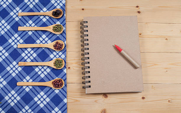 istock Cook book, kitchen tablecloth, spoon, fork on wooden 531864822