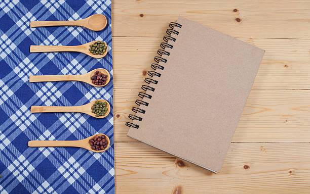 istock Cook book, kitchen tablecloth, spoon, fork on wooden 531864930