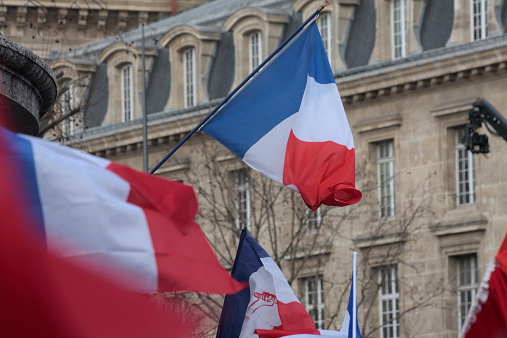 Paris, France - January 11, 2015: French flag during manifestation on Republic Square in Paris against terrorism and in memory of the attack against satirical newspaper Charlie Hebdo.