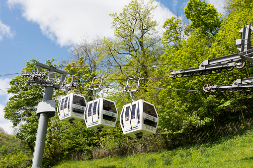 Matlock, UK - May 14, 2016: Three cable cars at the 'Heights of Abraham' landmark in the Peak District. Popular tourist destination. Logos on the cars and various people inside.