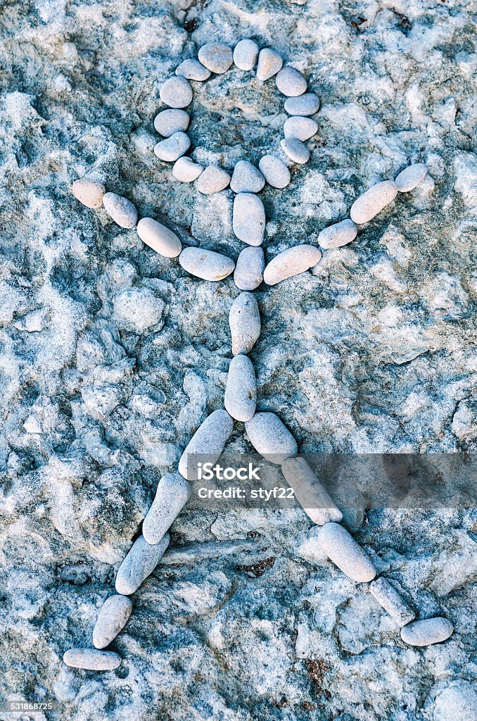 Figure from pebbles Human figure laid out from pebbles on the textured background. 2015 Stock Photo