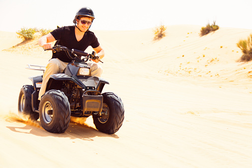 tourist riding a quad bike in the desert