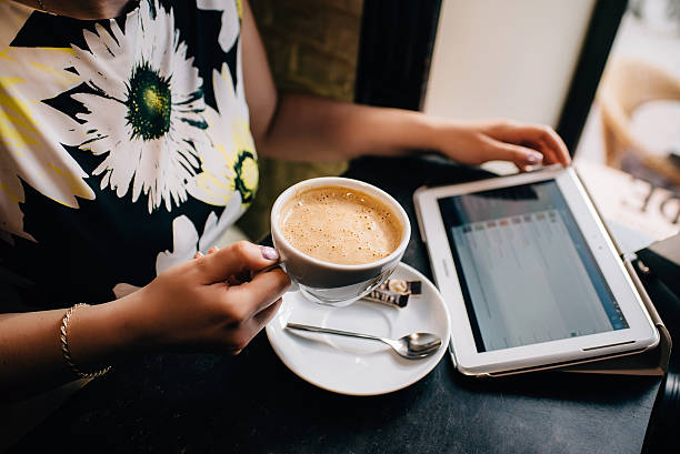 istock female hands holding coffee checks email on the tablet. 531869690
