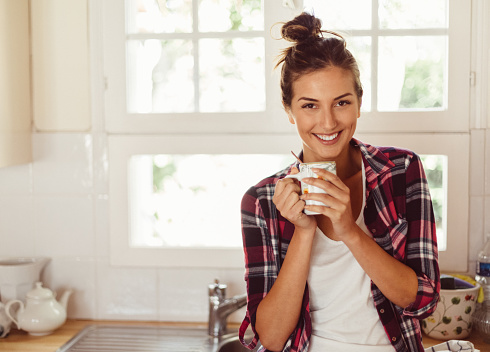 Young woman with coffee cup smiling to the camera