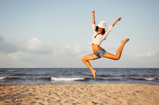 Tourist jumping from joy at the beach