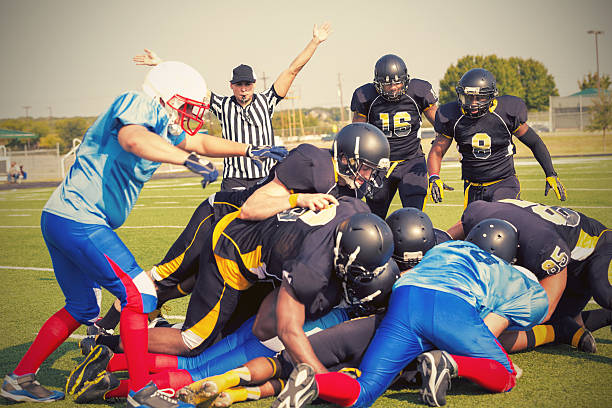 istock Referee blowing whistle after tackle during football game 531883177