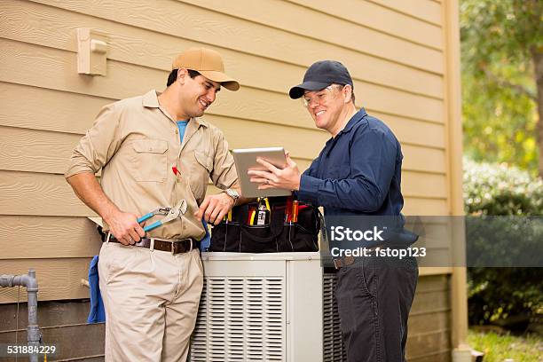 Air Conditioner Repairmen Work On Home Unit Blue Collar Workers Stock Photo - Download Image Now