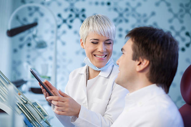 istock Dentist showing male patient x-rays on tablet. 531884373